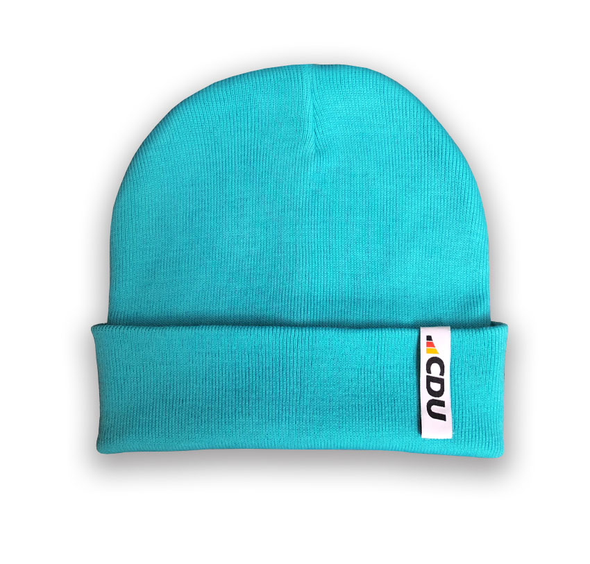 Gestrickte Mütze in Türkis. Am Mützenumschlag ist eine weiße Schlaufe aufgenäht mit 3-farbigem CDU-Logo.