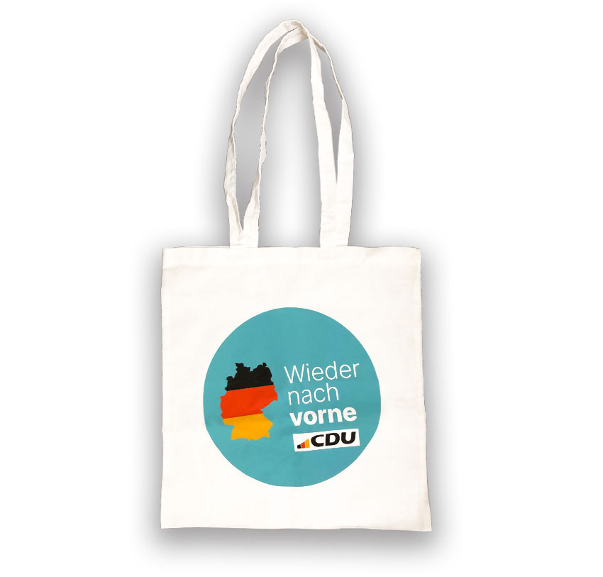 Weißer Tragebeutel mit langen Henkeln. Aufdruck: Großer Kreis in Türkis mit Deutschlandkarte in Schwarz, Rot, Gelb und mit Text in Weiß: Wieder nach vorne. CDU-Logo.