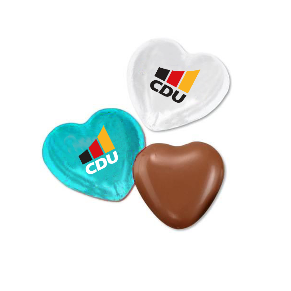 Drei Schokoladenherzen nebeneinander. Zwei Herzen sind in Stanniolfolie eingewickelt. Ein Herz in Türkis und ein Herz in Weiß. Beide sind mit dem CDU-Logo bedruckt. Das dritte Schokoladenherz ist unverpackt.