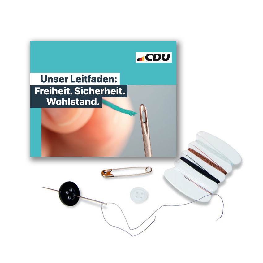 Nähetui aus Karton, mit Textdruck: Unser Leitfaden: Freiheit, Sicherheit, Wohlstand. Und CDU-Logo. Vor dem Etui sind die Utensilien abgebildet, die sich im Etui befinden.