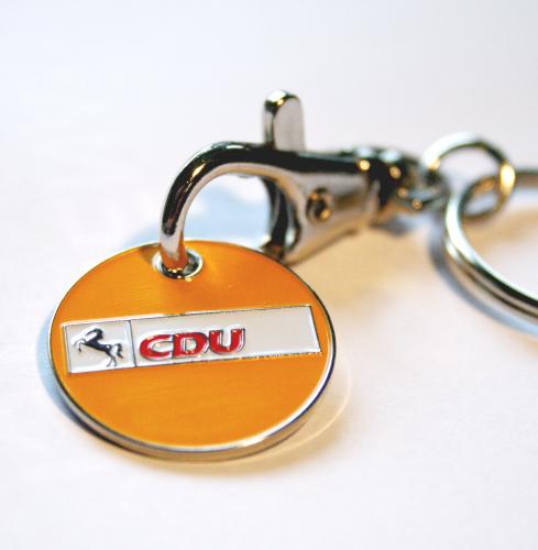 Einkaufswagenchip aus Metall, mit Farbe Orange eingelegt und das CDU-Logo Niedersachsen erhaben geprägt. Chip hängt an einem kleinen Karabiner mit Schlüsselring.