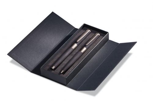 Kartonfaltschachtel in Schwarz, aufgeklappt. Mit schwarzer Schaumstofffüllung in die zwei Schreibgeräte eingesteckt sind.